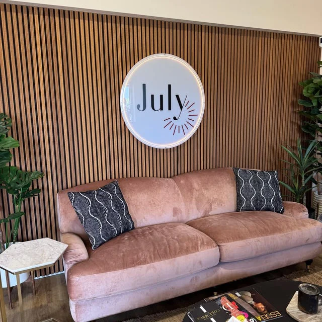 Haley’s customer-submitted photo of a round July sign on a wood-slat wall